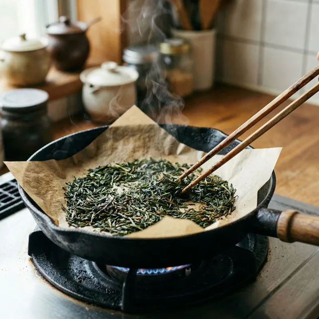 フライパンにクッキングペーパーを敷いて茶葉をのせ、弱火でゆっくり炒る様子