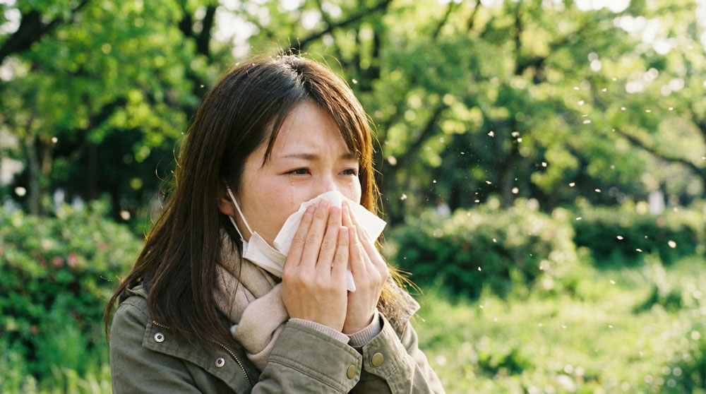 花粉症でくしゃみをする女性